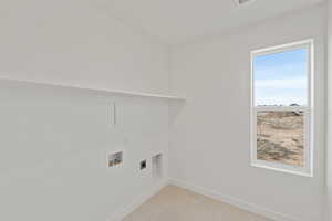 Laundry area featuring hookup for a washing machine, electric dryer hookup, and light tile patterned floors