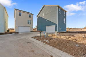 View of property exterior featuring driveway, a garage, and stucco siding