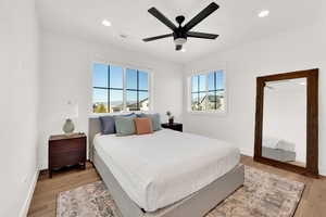 Bedroom with light wood finished floors, a ceiling fan, and recessed lighting