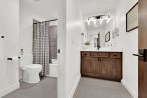 Full bath with vanity, light tile patterned floors, and shower / bath combo with shower curtain