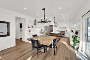 Dining space with suspended lighting and light wood finished floors