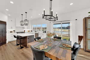 Dining room featuring suspended lighting and light wood-style floors
