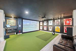 Playroom with golf simulator and a textured ceiling