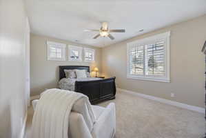 Bedroom featuring light colored carpet and a ceiling fan
