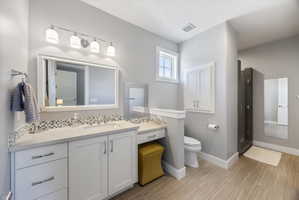 Bathroom featuring vanity, a stall shower, and tasteful backsplash