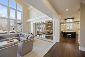 Living area with dark wood-style floors, a mountain view, recessed lighting, and decorative columns