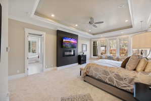 Bedroom featuring recessed lighting, crown molding, carpet floors, a glass covered fireplace, and ceiling fan