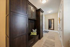 Mudroom with light tile patterned flooring and baseboards