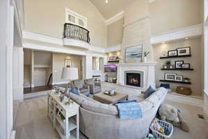 Carpeted living area with a lit fireplace and vaulted ceiling