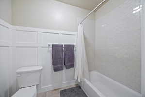 Full bathroom with shower / bath combo with shower curtain and light wood-style floors