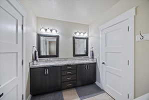 Bathroom featuring double vanity and a textured ceiling