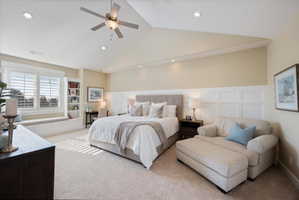 Carpeted bedroom featuring a decorative wall, lofted ceiling, ceiling fan, and recessed lighting