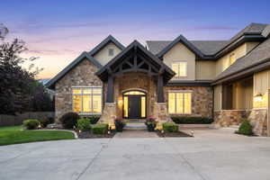 View of front of property featuring stone siding, a standing seam roof, and a shingled roof