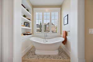 Full bath with a freestanding bath, wainscoting, and built in features