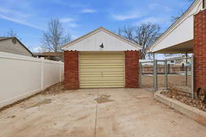 Detached garage with a gate and driveway