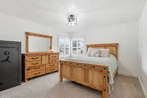 Bedroom featuring light carpet and baseboards