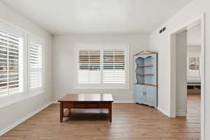 Living area featuring light wood finished floors and a textured ceiling