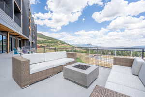 View of patio featuring an outdoor living space with a fire pit and a mountain view