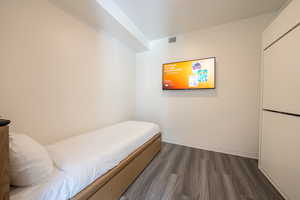 Bedroom featuring dark wood-style flooring and baseboards