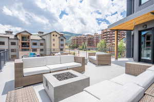 View of patio / terrace with an outdoor living space with a fire pit and a mountain view