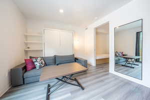 Living area with wood finished floors and baseboards