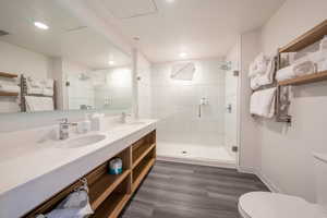 Full bath featuring a stall shower and double vanity