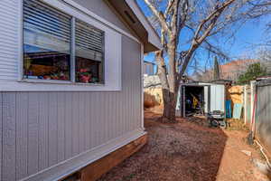 View of side of property with a storage shed and a fenced backyard