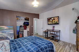 Bedroom featuring wood tiled floors, a closet, and a textured ceiling