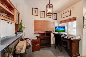 Office space featuring suspended lighting and light carpet