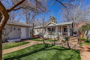 View of front of property with a shingled roof, an outbuilding, and board and batten siding