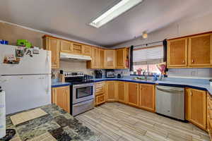 Kitchen with stainless steel appliances, wood finish floors, and wood finish cabinets