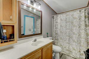 Full bath with a shower with curtain, vanity, and ornamental molding