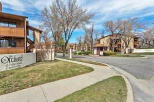 View of asphalt street featuring a residential view, curbs, and sidewalks