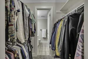 Walk in closet with light tile patterned floors