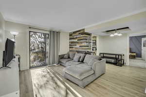 Living area with light wood-style flooring and crown molding