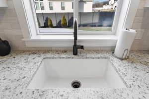 Kitchen view of a sink and light stone countertops