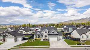 View of front of home featuring board and batten siding, concrete driveway, a mountain view, and a residential view