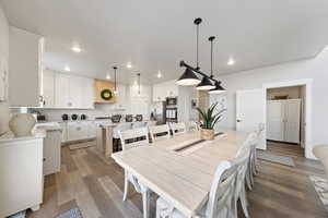 Dining space with light wood finished floors and recessed lighting