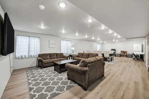 Living room with light wood finished floors and recessed lighting