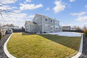 Rear view of house featuring a fenced backyard, board and batten siding, entry steps, a patio area, and an outdoor structure