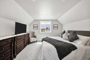 Bedroom featuring light carpet and baseboards
