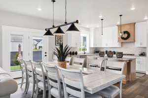 Dining area with dark wood-style floors and recessed lighting