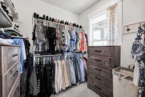 Walk in closet with light carpet