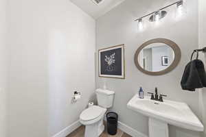 Bathroom with toilet and wood finished floors