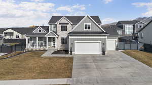 View of front of house with board and batten siding, a residential view, driveway, and stone siding