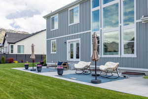 Rear view of house featuring board and batten siding, a patio, and french doors