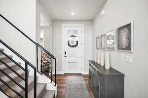 Foyer entrance with dark wood-type flooring and recessed lighting
