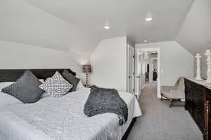 Bedroom featuring vaulted ceiling and light carpet
