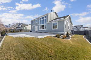 Back of property with board and batten siding, a residential view, and a patio