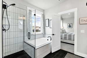 Bathroom featuring a shower stall, ensuite bathroom, dark tile patterned flooring, a garden tub, and dark colored carpet